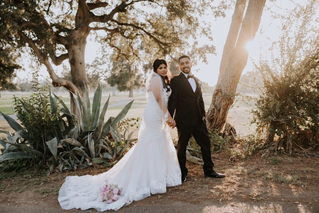 Bride and Groom standing by palm tree