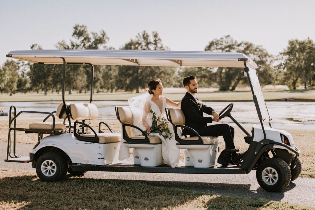 Bride and groom riding in a golf cart on the golf course after their wedding ceremony at The Pavilion at Haggin Oaks in Sacramento.