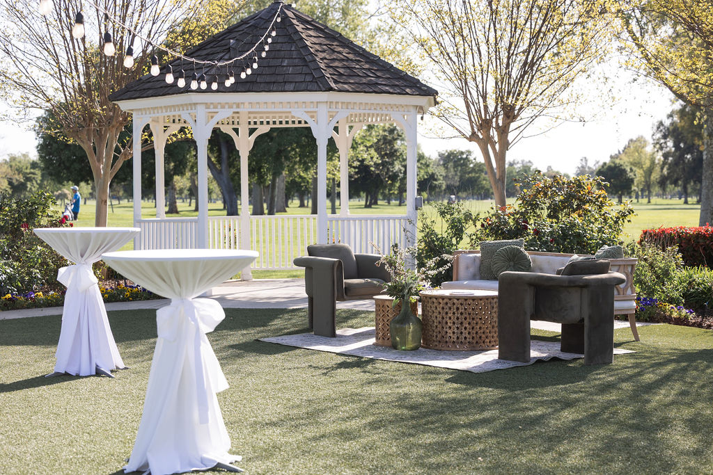 Outdoor gathering space at The Pavilion at Haggin Oaks featuring a white gazebo, lounge seating, cocktail tables, and golf course views in Sacramento.