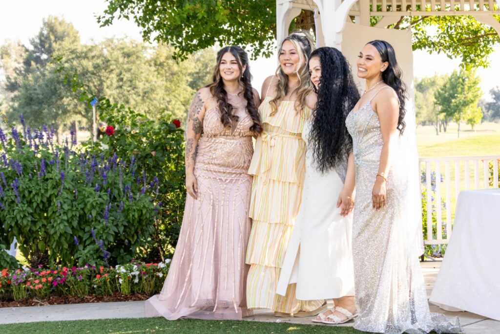 Group of guests posing for a photo beside the gazebo and garden area at The Pavilion at Haggin Oaks during a celebration in Sacramento.