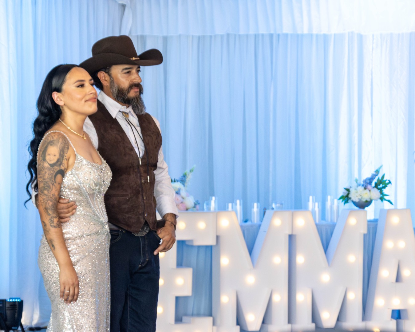 Couple posing in front of illuminated marquee letters during a quinceañera celebration at The Pavilion at Haggin Oaks in Sacramento.
