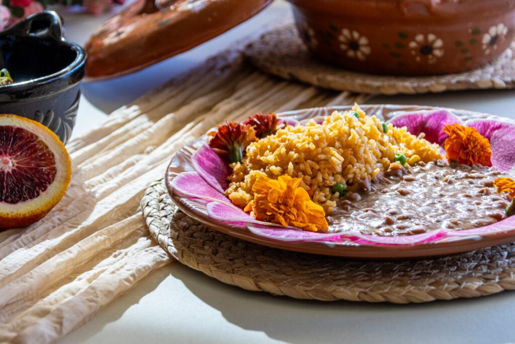 Spanish rice and refried beans garnished with edible flowers, served as part of a Mexican-inspired catered event menu at The Pavilion at Haggin Oaks.