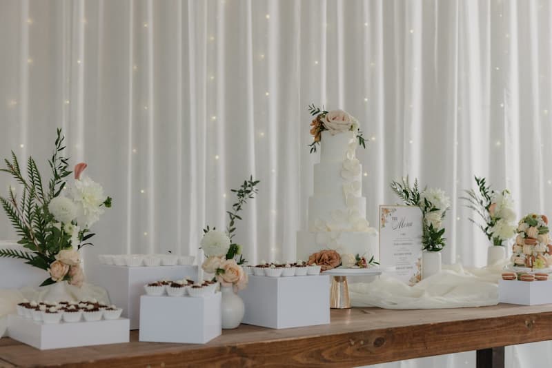 Wedding cake and dessert display with floral decorations at Creekside at Haggin Oaks.